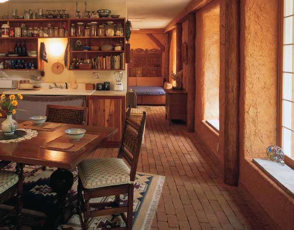 Designed so that the southern sun beams all the way across the main room at Winter Solstice, Hanuman’s house is a natural passive solar collector. Locally made bricks absorb the radiant heat by day and release it back into the room at night. The interior walls are plastered with a mixture of clay from Hanuman’s yard (the Charlottesville area is said to have the best clay for adobe in the country), lime, and sand; the adobe gives